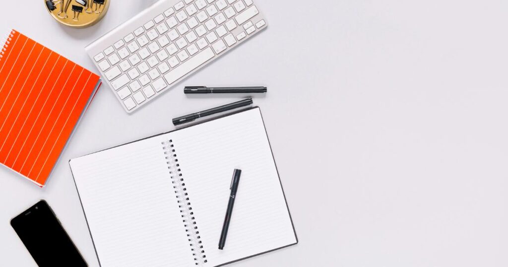 A small physical notebook on a desk used to safely write down passwords and logins.