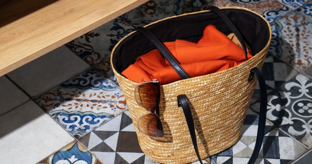 Woven basket in the corner of a room used to store semi-clean clothes.