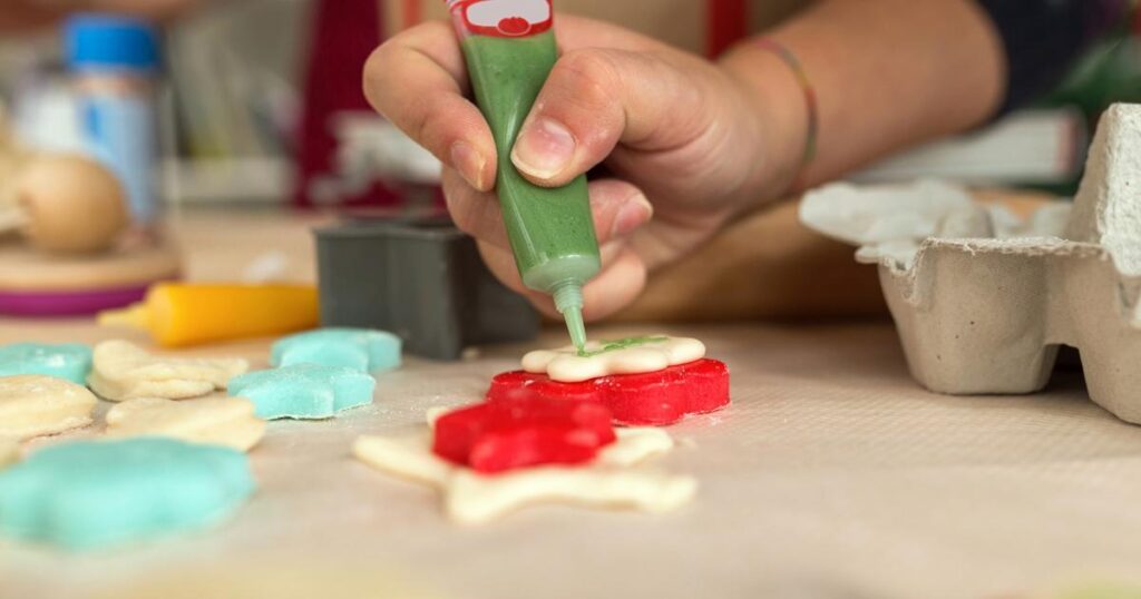 Hands assembling a complex LEGO set or molding clay on a table.
