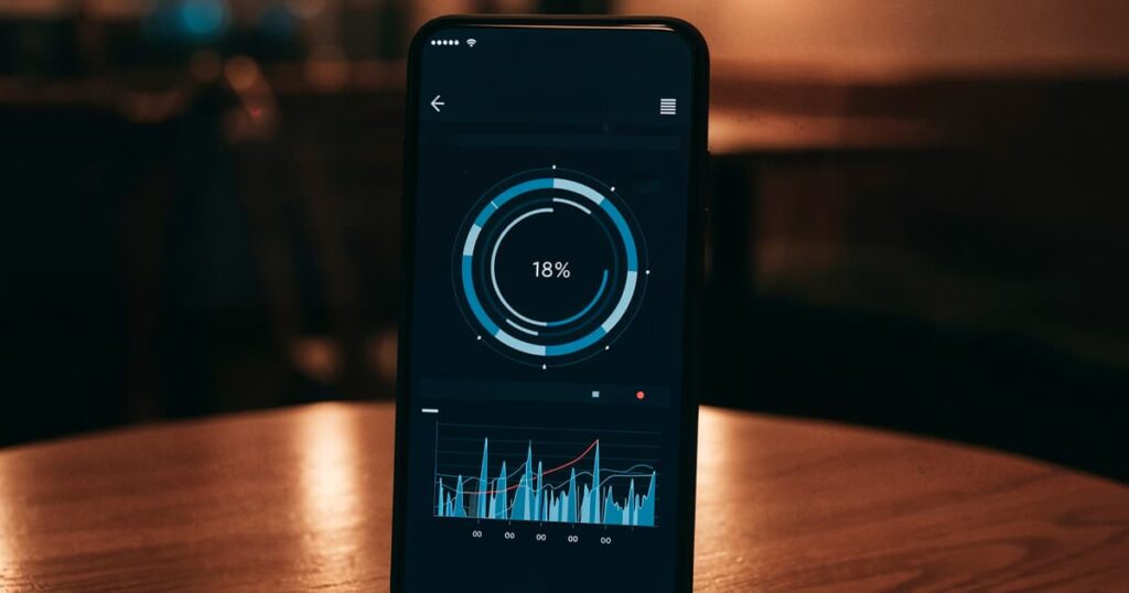A smartphone screen mounted on a dashboard showing an audiobook or podcast playing.