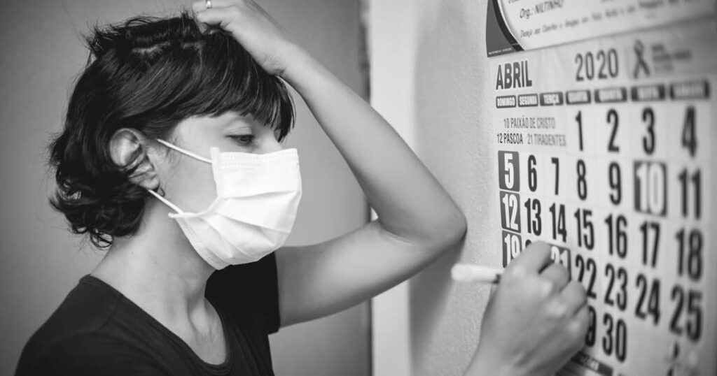 A calendar showing the transition from Sunday to Monday with a sad face drawn on Monday.