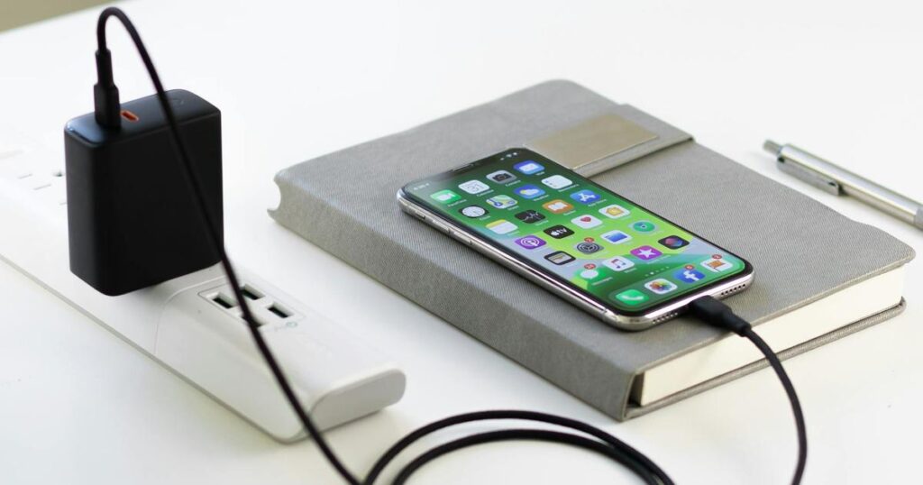 A neat charging station with a phone, watch, and earbuds all plugging in to charge.