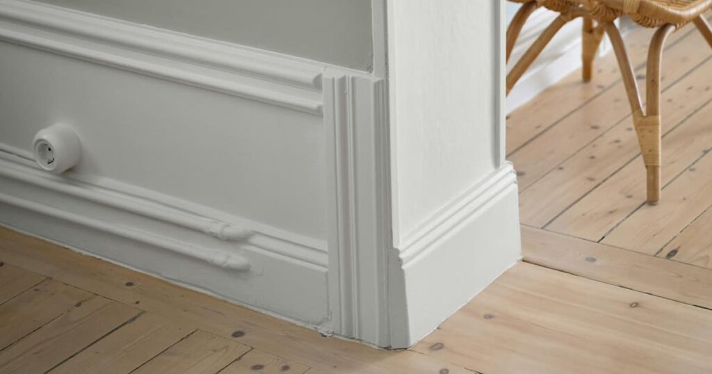 An empty, clean corner of a room with a plant, showing the peace of minimalism.