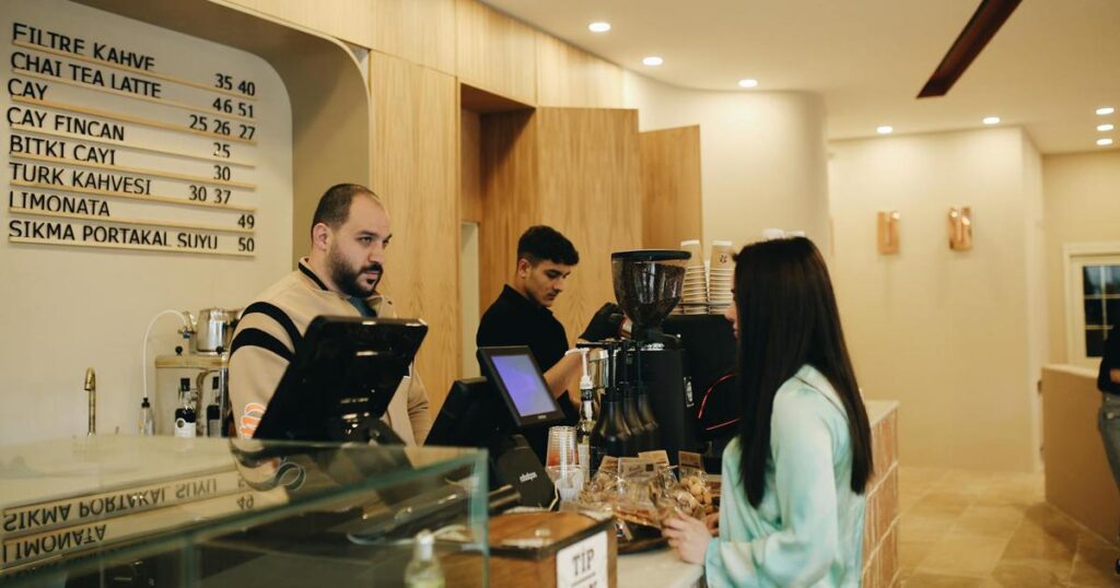 A person confidently ordering coffee at a cafe counter without looking nervous.