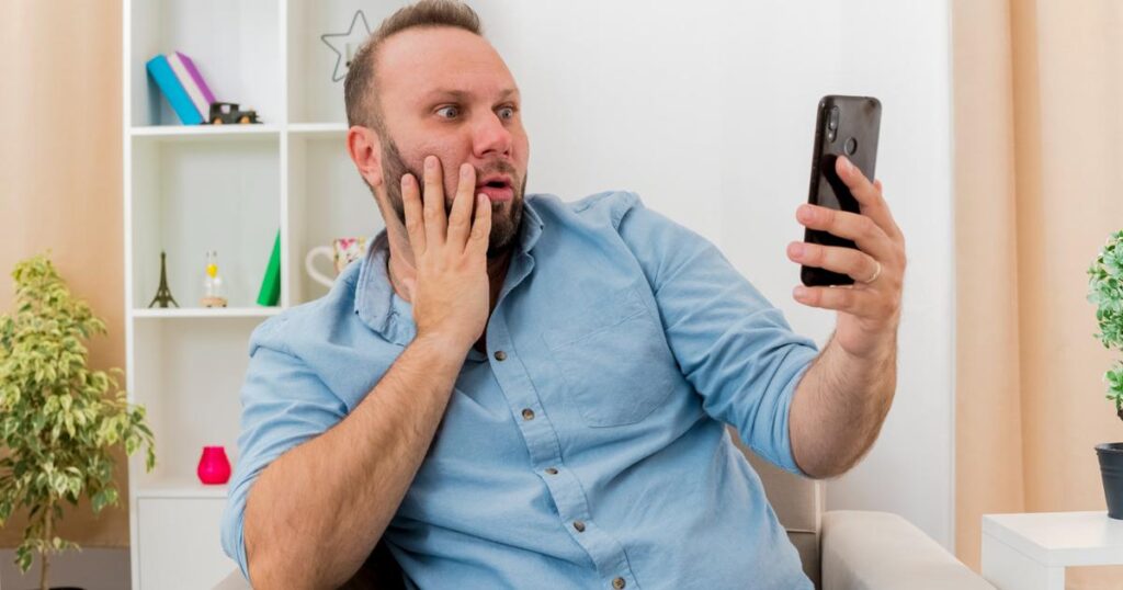 A person looking shocked at their phone screen, representing the embarrassment of old search history popping up.