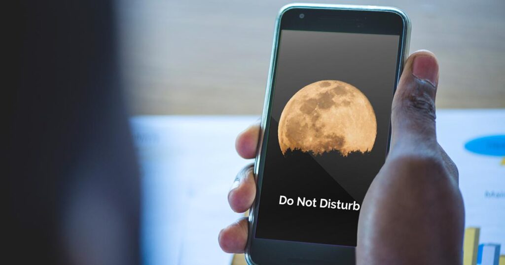 A close up of the moon icon representing Do Not Disturb mode enabled on a phone.