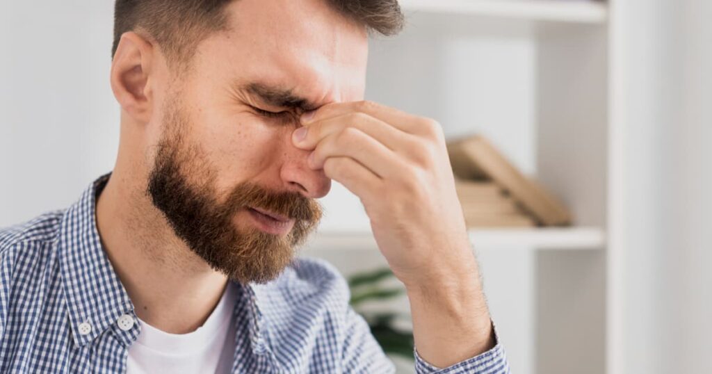 A close up of a person's eye or face looking tired, representing the eye twitch symptom.
