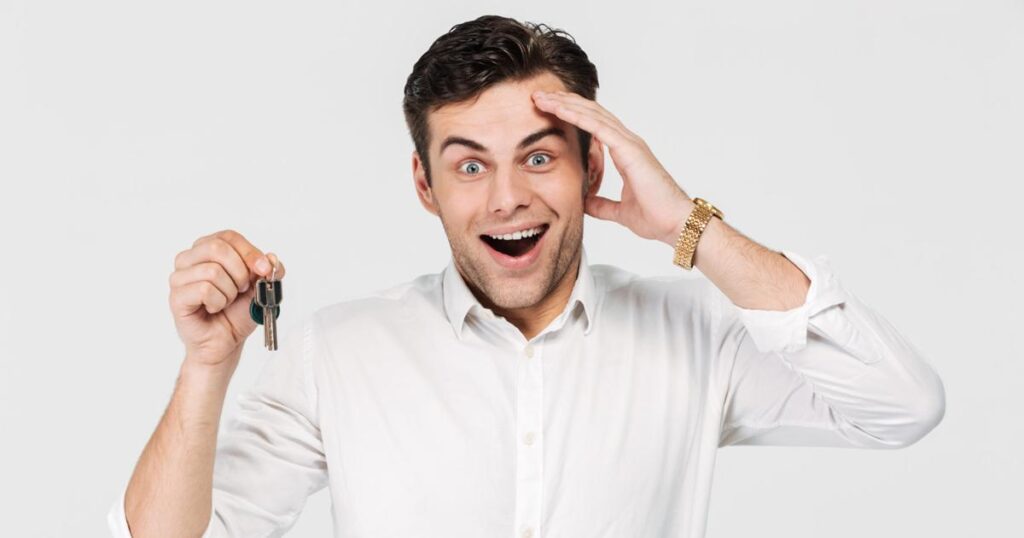 A person holding their car keys with a relieved expression after searching for them.