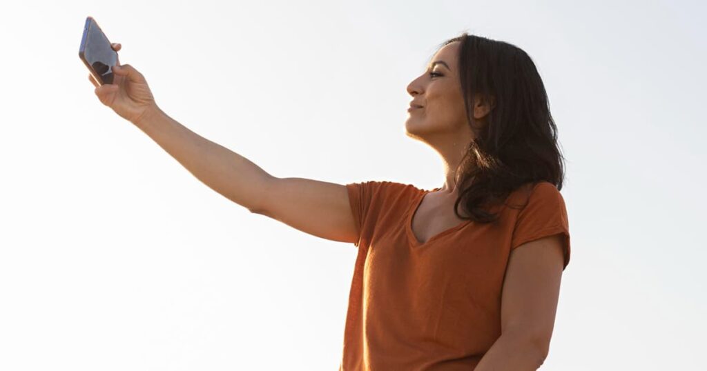 A person taking a selfie from a high angle, showing their preferred side of their face.