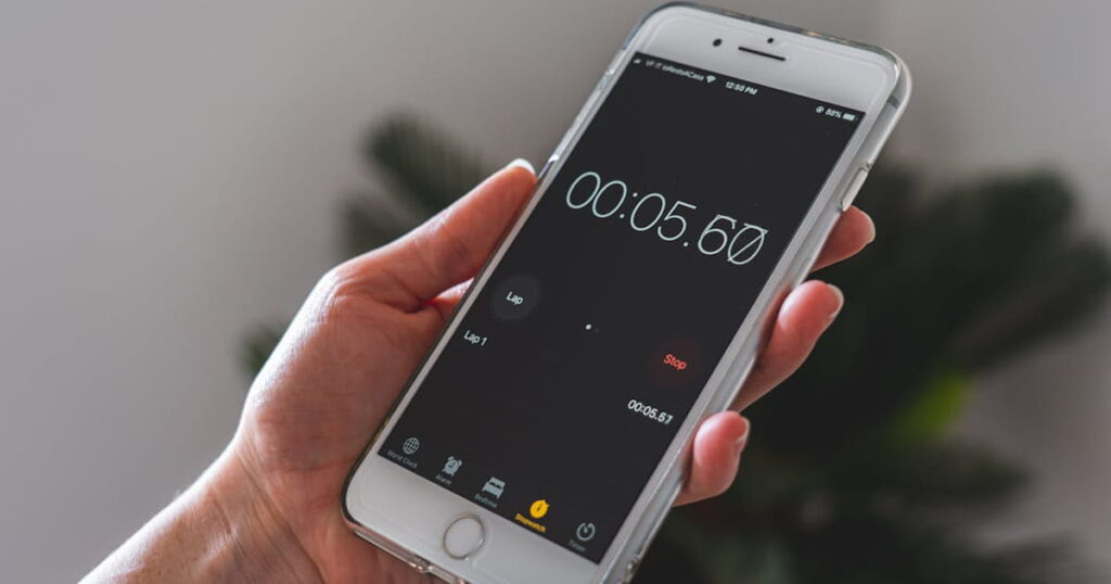 A digital kitchen timer set to 5 minutes sitting on a desk.