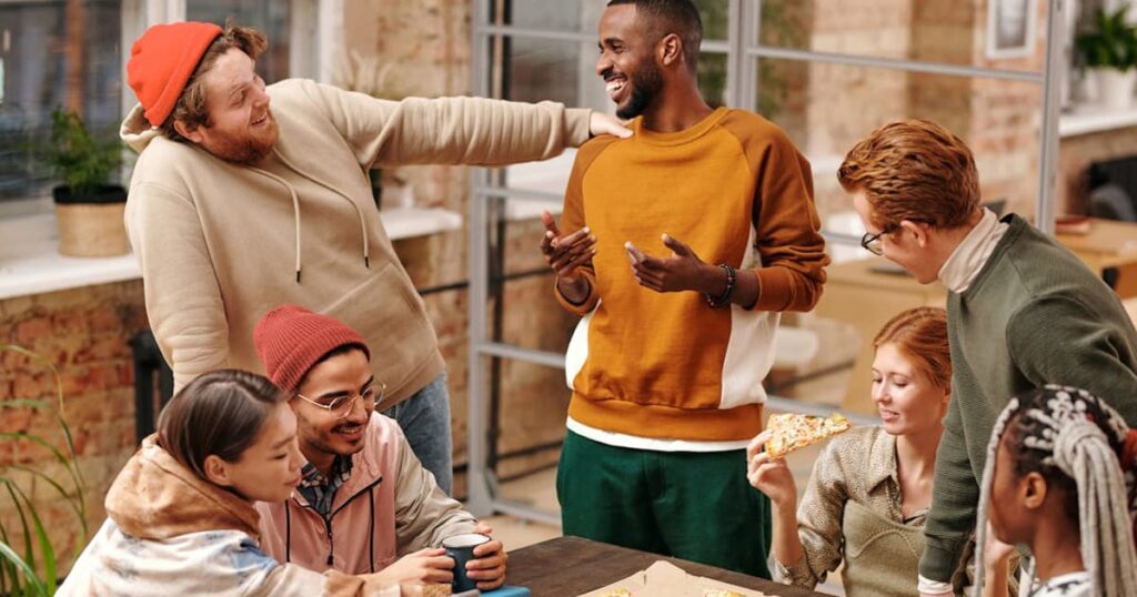 A group of friends laughing and talking, representing how others naturally hear your voice.
