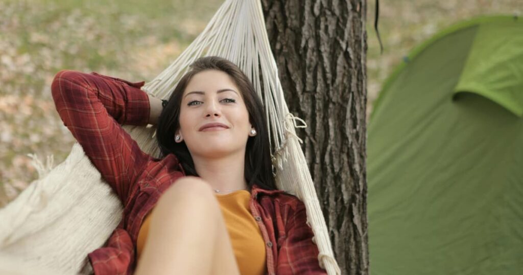 A person sleeping happily in a hammock, representing the guilt-free relaxation after finishing work.