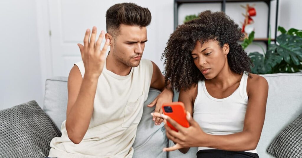 A person looking at a glamorous photo on a phone and feeling small, representing the comparison trap.