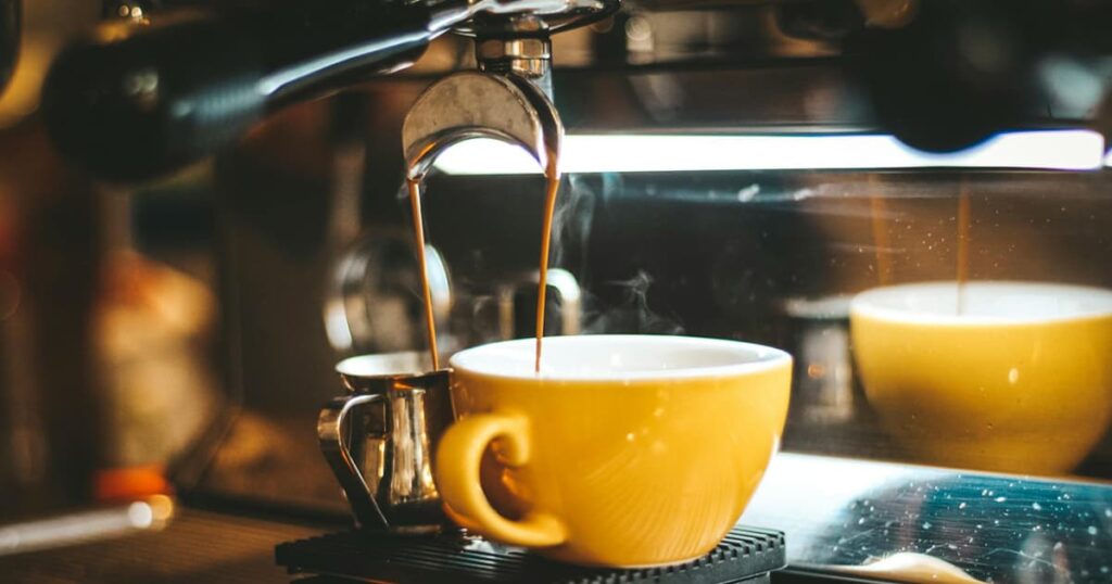 A coffee mug placed next to a coffee machine, prepared for the next morning.
