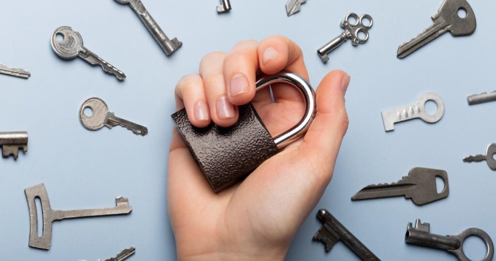 A close up hand holding a random key that doesn't look like it fits any lock in the house.