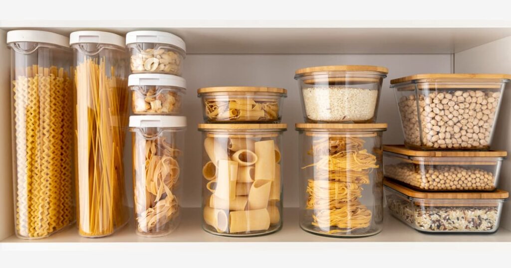 A neatly organized kitchen drawer where lids are stored vertically in a separate bin.