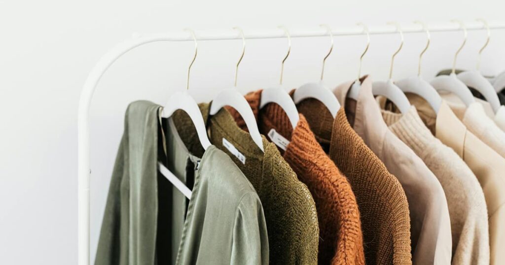 Clothes laid out on a bed or hung on a rack, organized for the upcoming week.