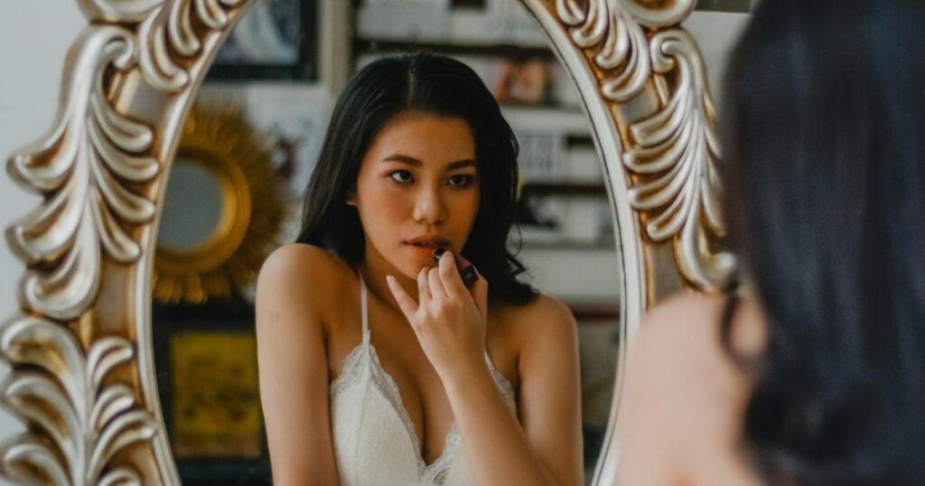 A person looking in a mirror and giving themselves a pep talk with a confident expression.