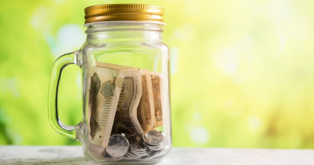 A piggy bank or money jar filling up, symbolizing the savings from staying home.