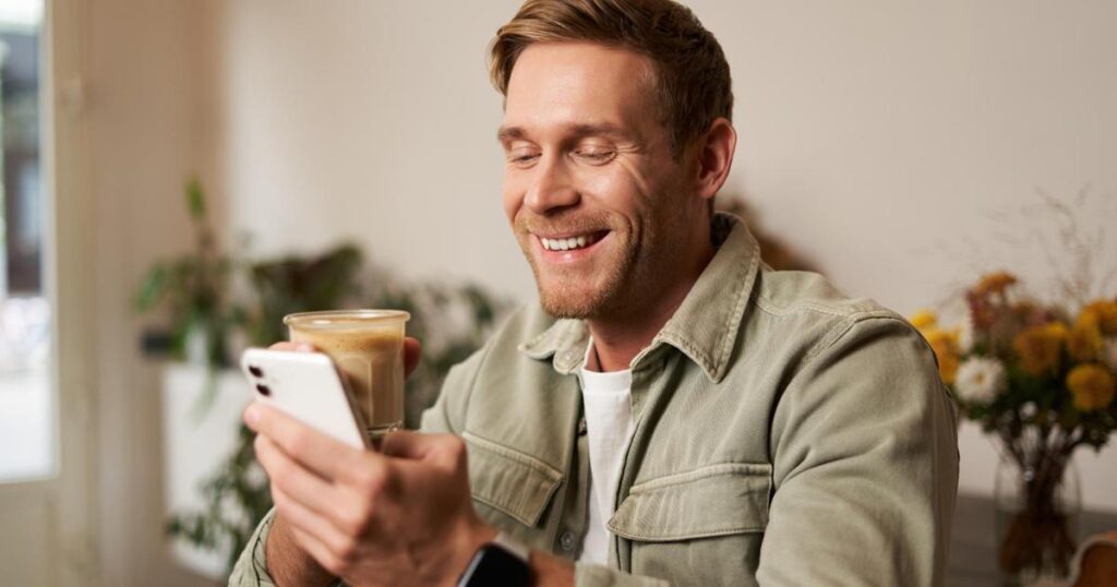 A person laughing at a meme on their phone, staying connected without effort.