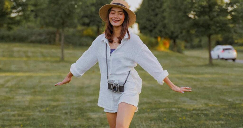  A person walking slowly in a park or nature setting, looking relaxed.