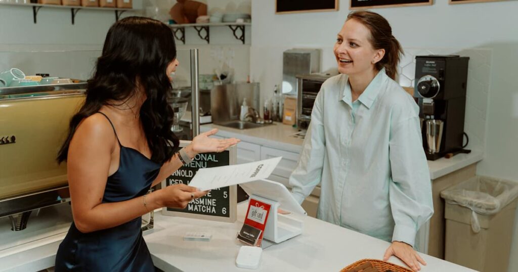 A barista smiling at a customer who is a "regular," showing a small but meaningful social connection.