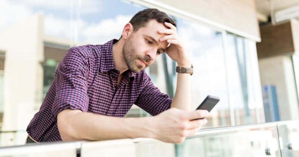 A person looking annoyed at their partner because they just watched an upsetting video on their phone.