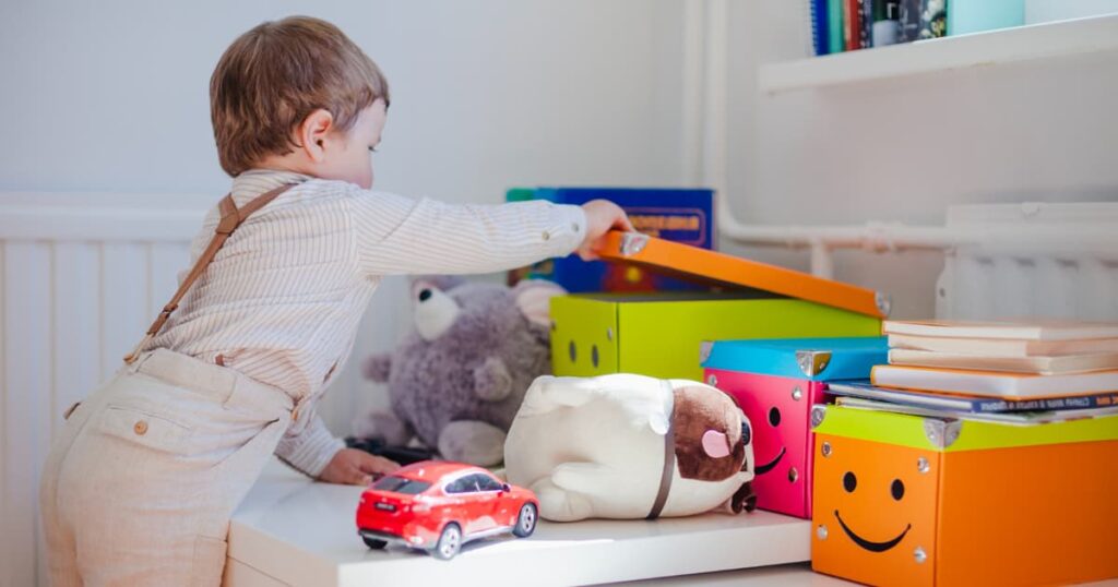 A parent taking a bin of "new" toys out of a closet to rotate them.