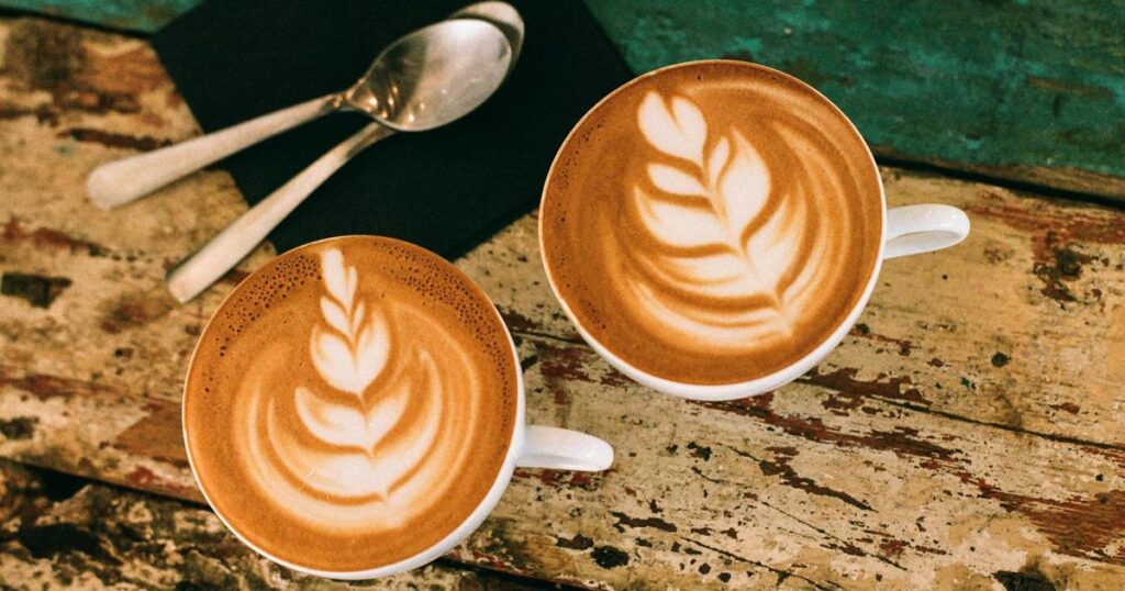 Two cups of coffee at a new cafe, representing trying something small and new.