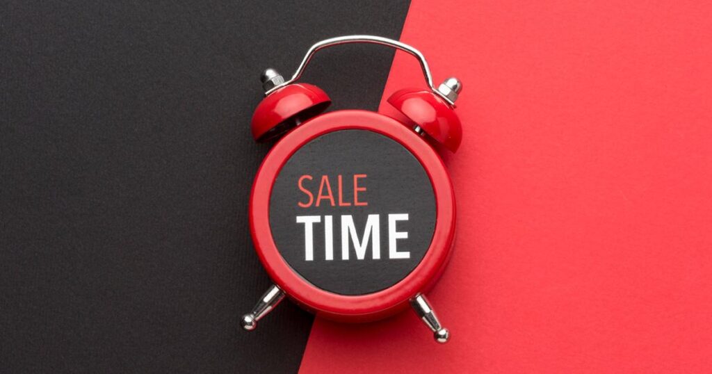 A modern analog wall clock with a red sector showing time remaining.