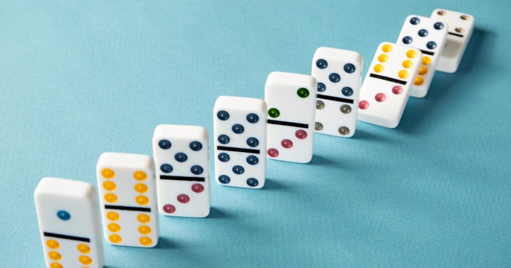 Dominoes falling in a perfect line representing the momentum of batched work.