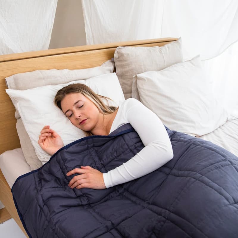 weighted blanket on bed for calming sleep